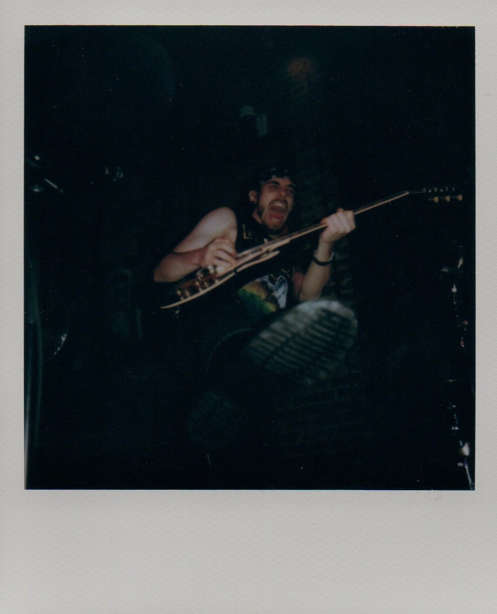 Quinn Colpman playing the guitar and kicking his foot forward.